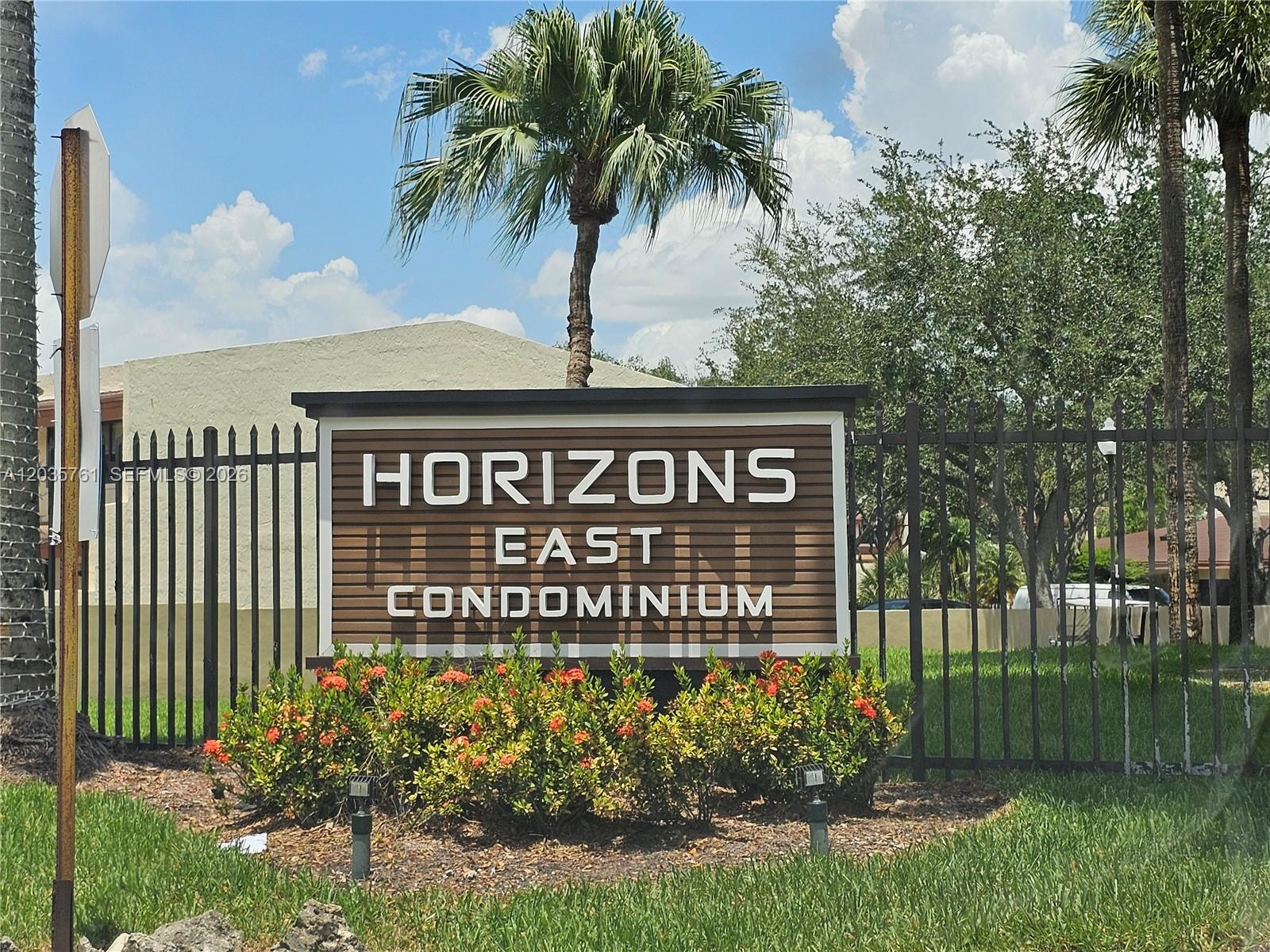 A sign for Horizons East Condominium stands behind a black metal fence and landscaping — 8075 SW 107th Ave # 114, Miami FL 33173, MIAMI, FL