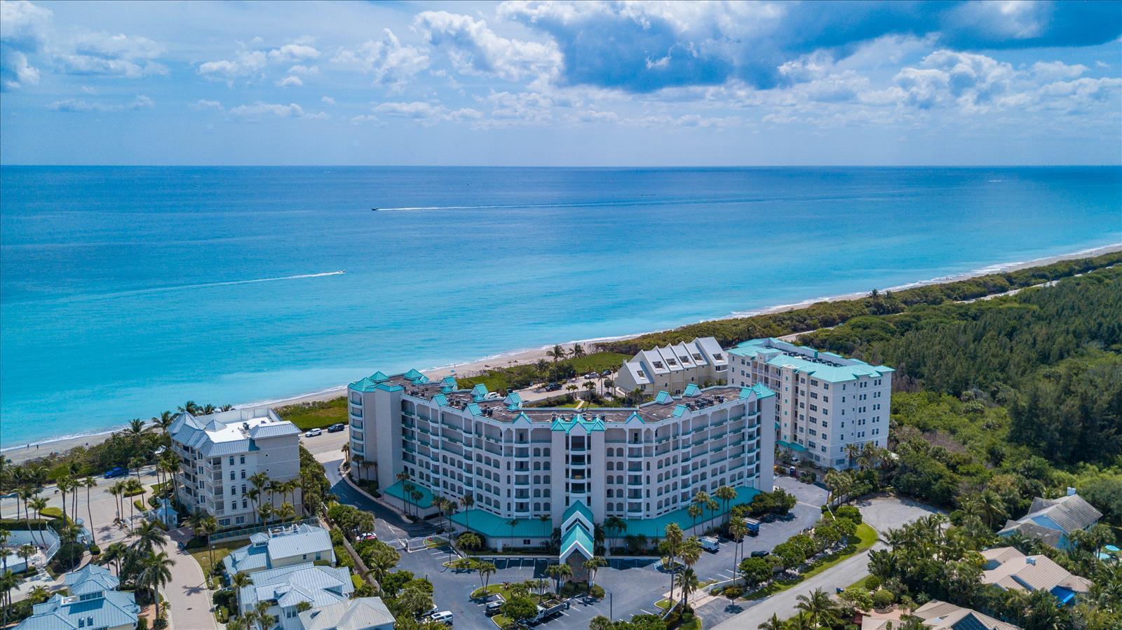 An aerial view shows a large beachfront resort complex surrounded by trees and the ocean — 2000 S Highway A1a # 603, Jupiter FL 33477, JUPITER, FL