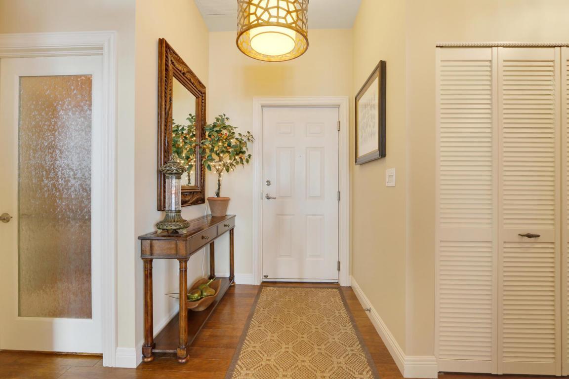 A foyer features a wooden console table, a mirror, a patterned runner, and a pendant light — 2000 S Highway A1a # 603, Jupiter FL 33477, JUPITER, FL