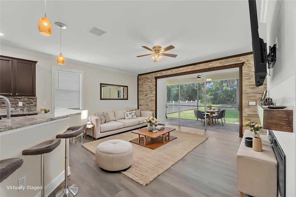 A bright foyer leads to a living area and dining room with exposed ceiling beams — 17433 NEW CROSS CIRCLE, LITHIA, FL