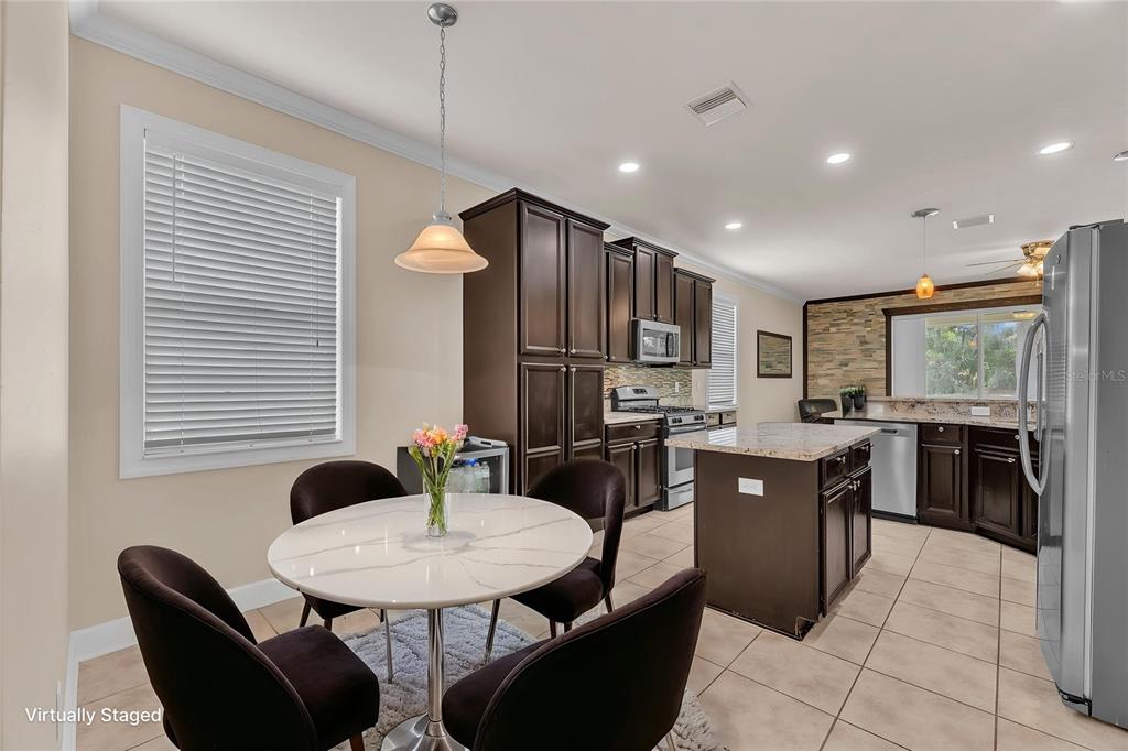 A kitchen with dark wood cabinets, granite countertops, a center island, and tile flooring — 17433 NEW CROSS CIRCLE, LITHIA, FL