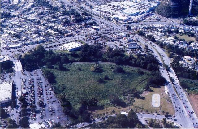 An aerial view shows a large, undeveloped green lot surrounded by roads and commercial buildings — PR-29 INT DEGETAU ST., BAYAMON, PR