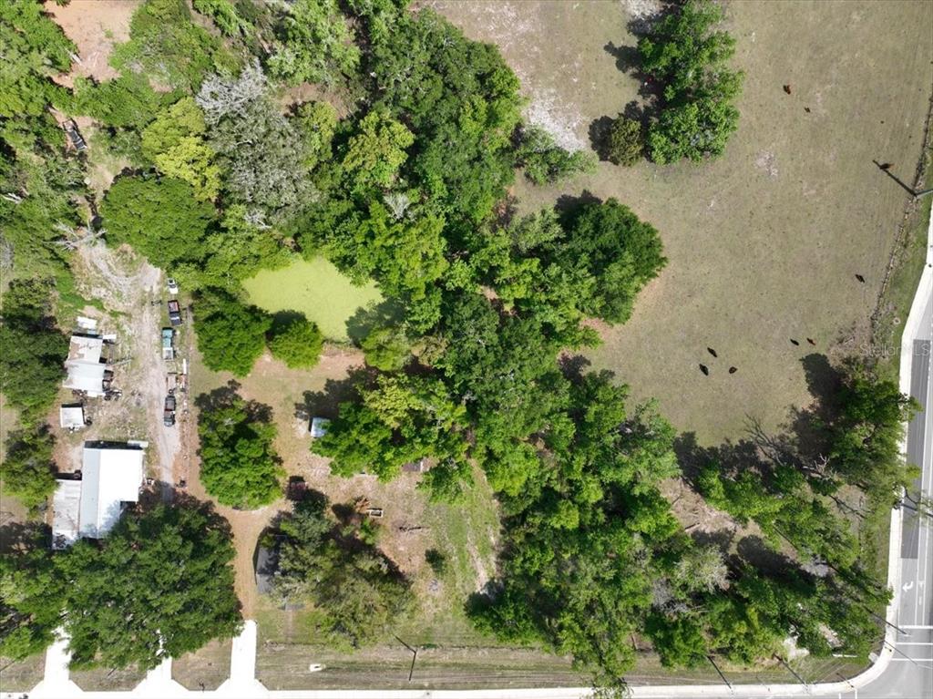 An aerial view shows a rural property with a pond, trees, and several small buildings — 1415 N WABASH AVENUE, LAKELAND, FL