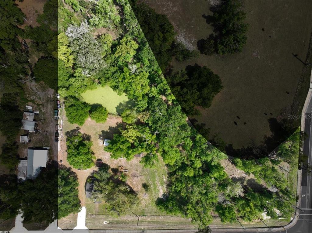An aerial view shows a wooded lot with a small pond and several structures — 1415 N WABASH AVENUE, LAKELAND, FL
