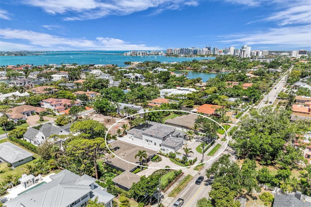 An aerial view shows a modern house with a flat roof surrounded by lush trees — 1516 S ORANGE AVENUE, SARASOTA, FL
