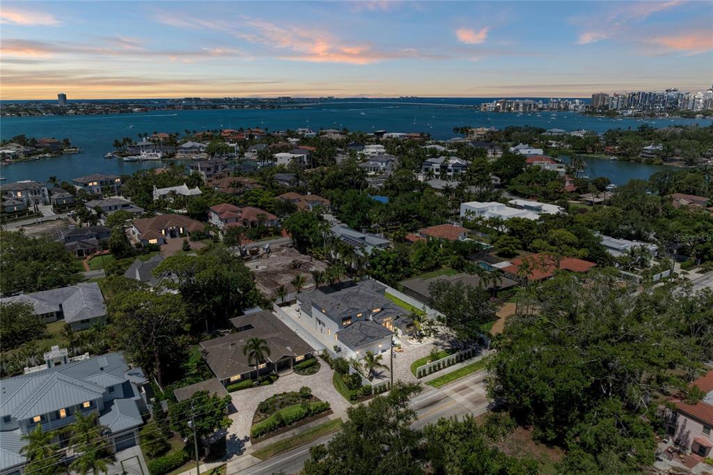 An aerial view shows a modern house with a gray roof surrounded by lush trees — 1516 S ORANGE AVENUE, SARASOTA, FL
