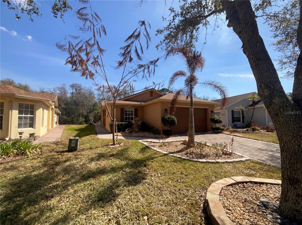 A tan single-story house with a two-car garage and a paved driveway — 396 GRAND CANAL DRIVE, KISSIMMEE, FL