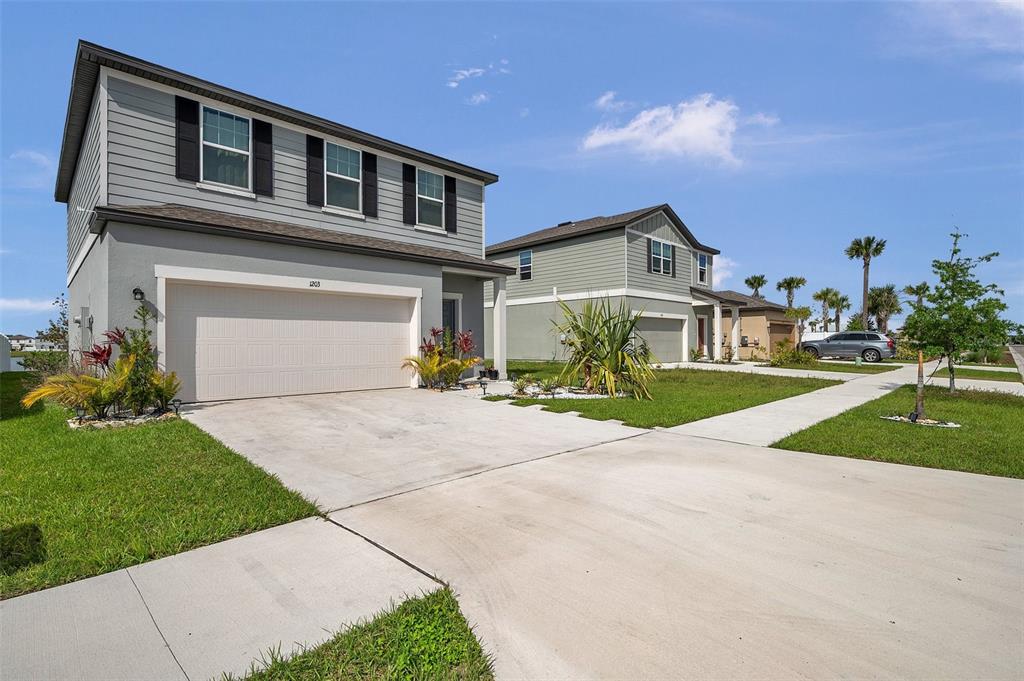 A two-story gray house with a two-car garage and a concrete driveway — 1203 7TH AVENUE NW, RUSKIN, FL