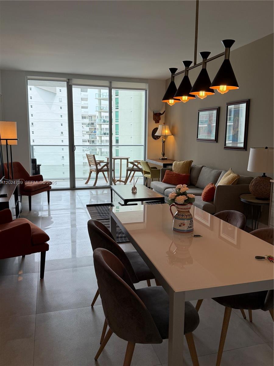 A modern living and dining area features tile floors, a balcony, and a pendant light — 1300 Brickell Bay Dr # 1007, Miami FL 33131, MIAMI, FL