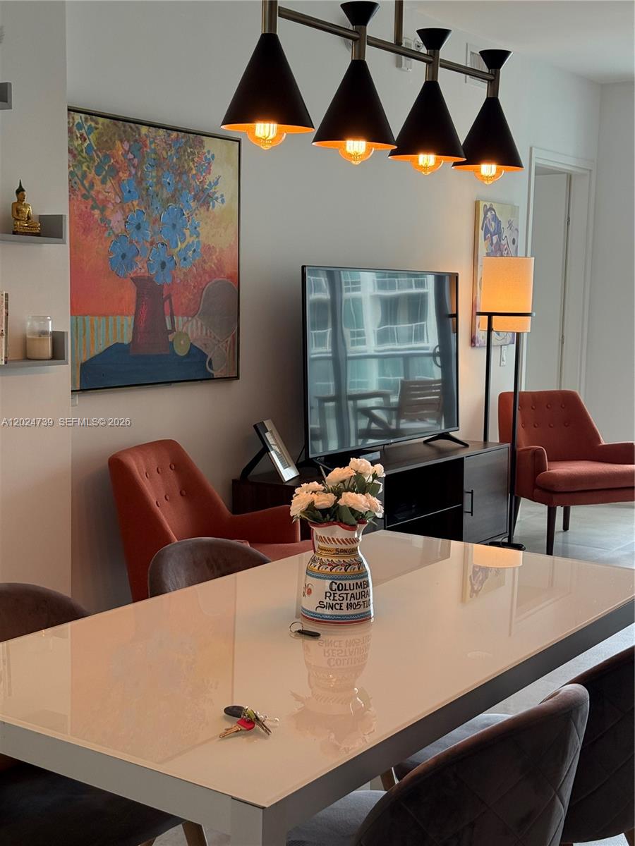 A dining area features a white table, four chairs, and a modern four-light pendant fixture — 1300 Brickell Bay Dr # 1007, Miami FL 33131, MIAMI, FL
