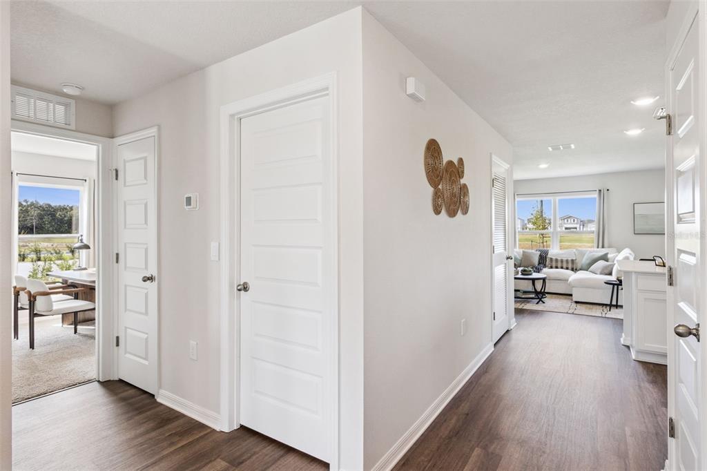 A hallway with wood-look flooring leads to a living area and a home office — 2791 ADELINE AVENUE, WINTER HAVEN, FL