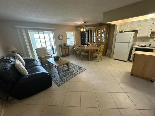An open-concept living and dining area features tile flooring, a kitchen, and sliding glass doors — 4980 E Sabal Palm Blvd # 330, Tamarac FL 33319, TAMARAC, FL