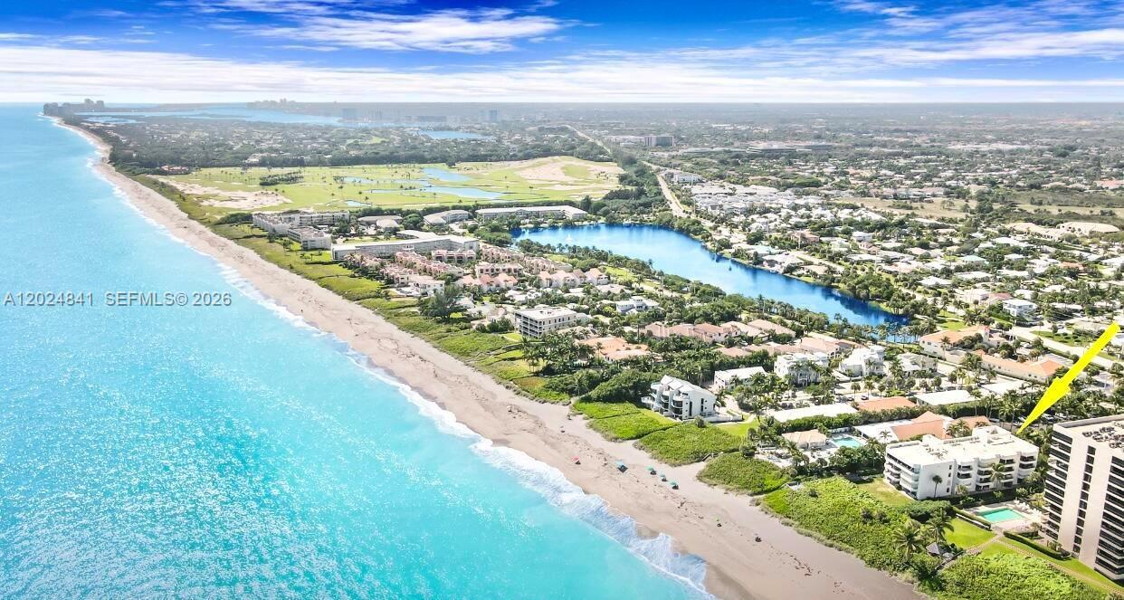 An aerial view shows a coastal residential complex situated between the ocean and a lake — 420 Celestial Way # 101, Juno Beach FL 33408, JUNO BEACH, FL