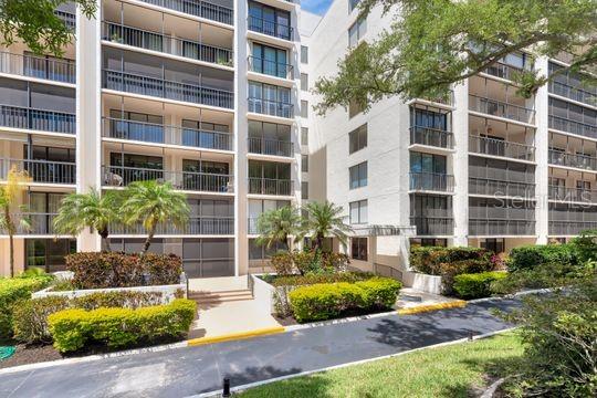 A multi-story apartment building with screened balconies and landscaped grounds in front — 220 BELLEVIEW BOULEVARD UNIT 203, BELLEAIR, FL