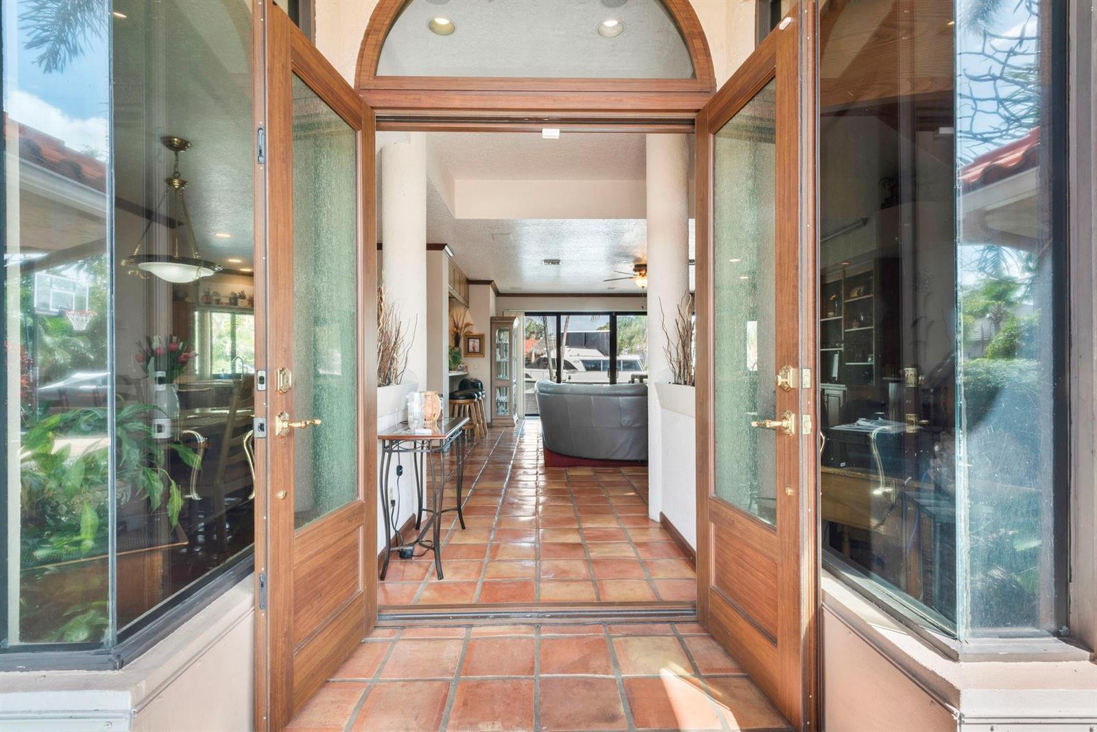 An open doorway reveals a tiled foyer leading to a living area with a view — 2865 NE 19th Street, Pompano Beach FL 33062, POMPANO BEACH, FL