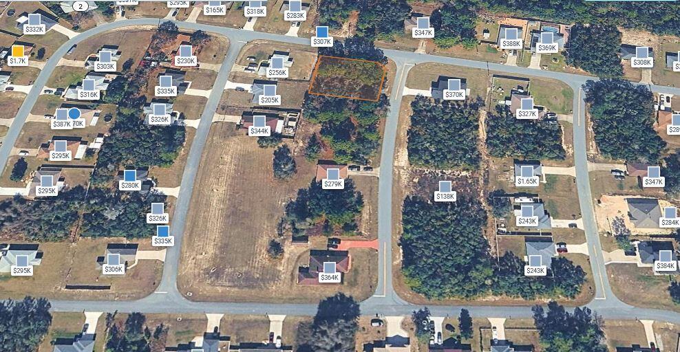 An aerial view of a residential neighborhood showing a vacant lot highlighted in orange — 00 SW 133 Loop, Ocala FL 34473, OCALA, FL