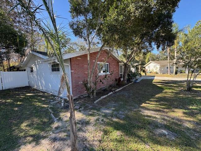 An empty bedroom features light yellow walls, wood-look laminate flooring, and a single window — 7235 REDBUD COURT, NEW PORT RICHEY, FL