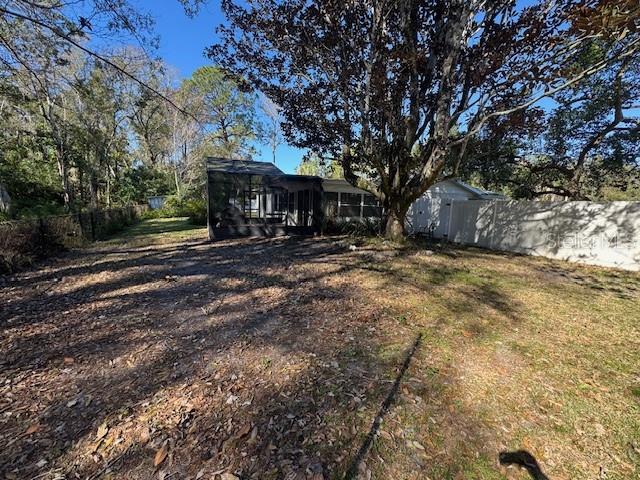 An empty room with light-colored walls, wood-look flooring, and a doorway leading to a hallway — 7235 REDBUD COURT, NEW PORT RICHEY, FL