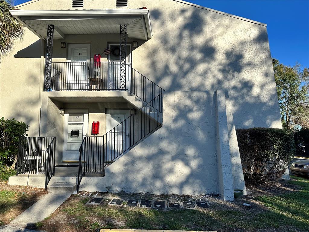 The exterior of a two-story apartment building features a metal staircase and balcony railings — 1103 CYPRESS GARDENS BOULEVARD UNIT 51, WINTER HAVEN, FL