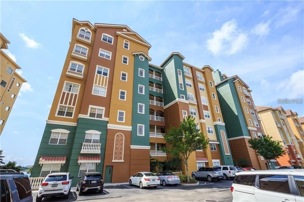 A multi-story apartment building with colorful stucco walls and a parking lot in front — 8749 THE ESPLANADE UNIT 30, ORLANDO, FL