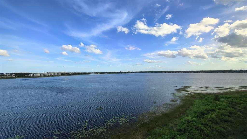 A wide view of a large lake under a blue sky with scattered clouds — 8749 THE ESPLANADE UNIT 30, ORLANDO, FL