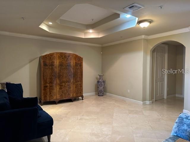 A living room features a coffered ceiling, tile flooring, a large wooden cabinet, and an archway — 8749 THE ESPLANADE UNIT 30, ORLANDO, FL