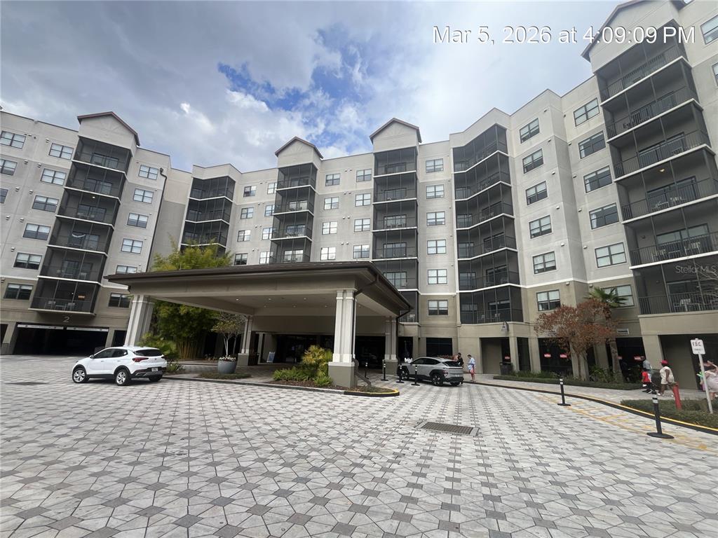 A multi-story apartment building with a covered entrance and a paved circular driveway — 14501 GROVE RESORT AVENUE UNIT 1732, WINTER GARDEN, FL