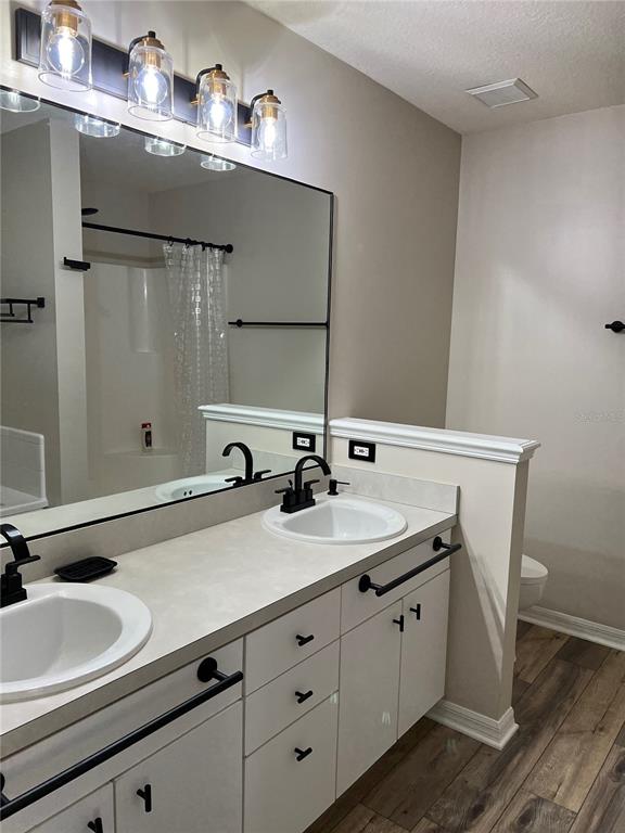 A bathroom features a double vanity with white cabinets, black hardware, and a large mirror — 6845 SW 81ST STREET, GAINESVILLE, FL