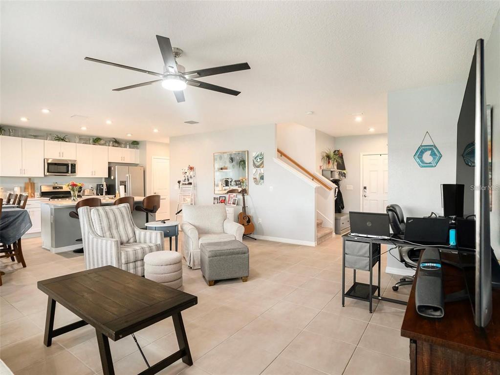 An open-concept living room and kitchen area features tile flooring and a ceiling fan — 5912 LAURELCREST GLEN, PALMETTO, FL