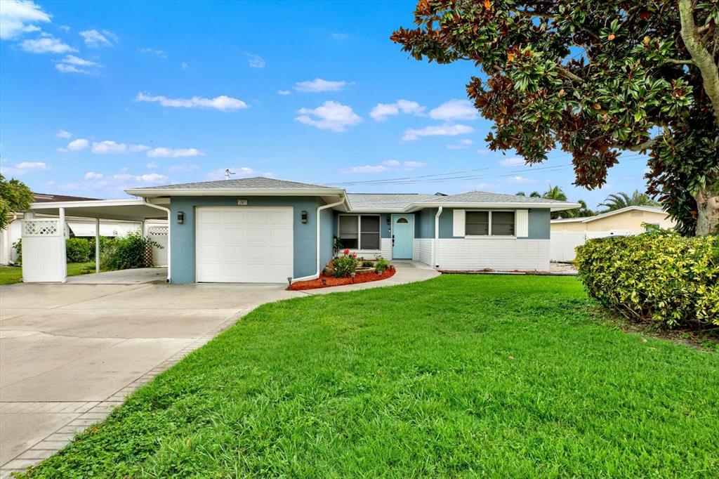 A single-story house with a blue exterior, white garage door, and a front lawn — 5995 BLOSSOM LAKE DRIVE, SEMINOLE, FL