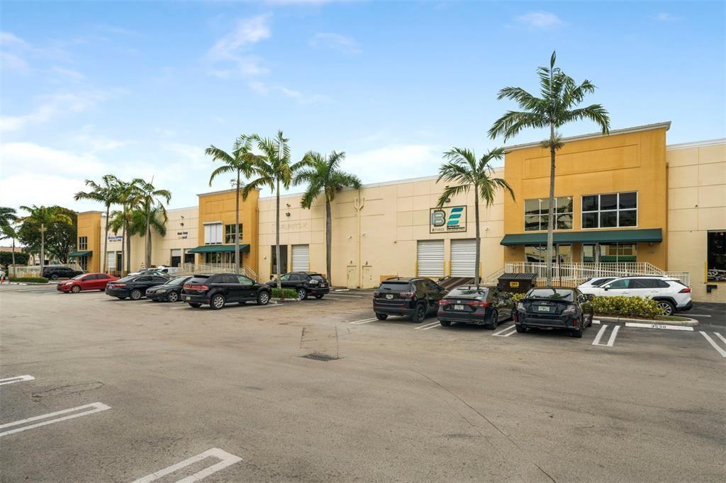 A parking lot sits in front of a row of commercial buildings with palm trees — 3530 NW 115th Avenue # 3530, Doral FL 33178, DORAL, FL
