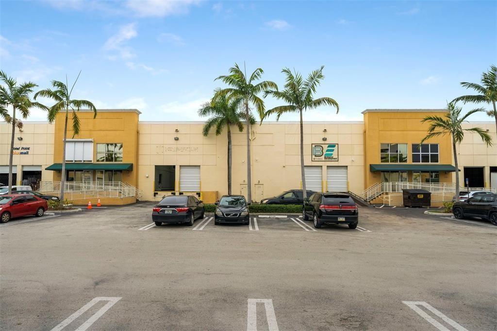 A commercial building exterior with a parking lot, palm trees, and several business entrances — 3530 NW 115th Avenue # 3530, Doral FL 33178, DORAL, FL