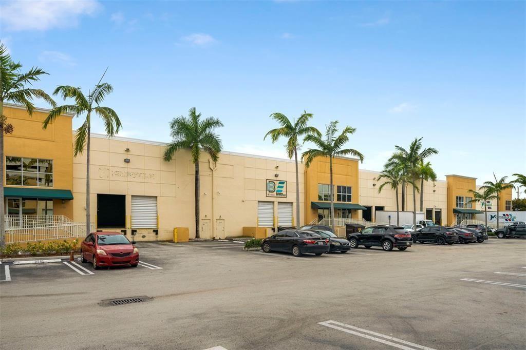 A low-rise commercial building with a parking lot and palm trees under a blue sky — 3530 NW 115th Avenue # 3530, Doral FL 33178, DORAL, FL