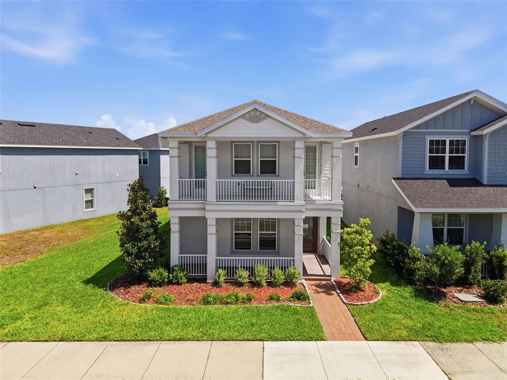 A two-story house with a front porch and balcony sits between two neighboring homes — 13631 RANGELAND BOULEVARD, ODESSA, FL