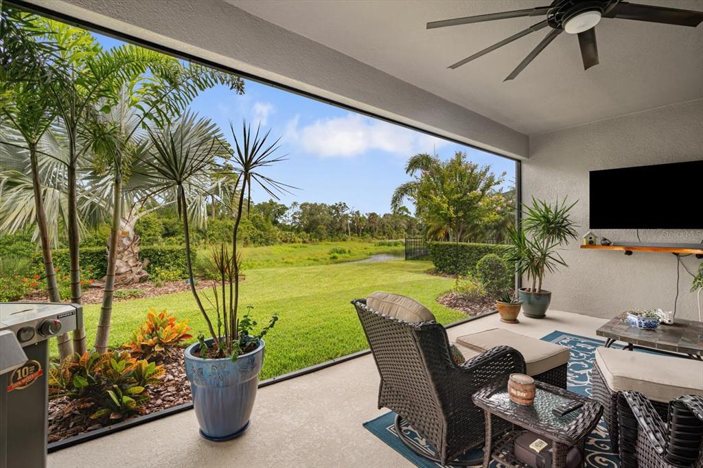 A screened-in patio features wicker furniture, a tile-topped coffee table, and a ceiling fan — 6502 MAIDEN SEA DRIVE, APOLLO BEACH, FL