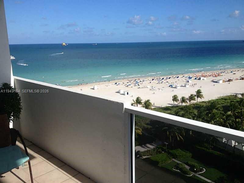 A balcony overlooks a sandy beach, the ocean, and a lush green landscape below — 100 Lincoln Rd # 1440, Miami Beach FL 33139, MIAMI BEACH, FL