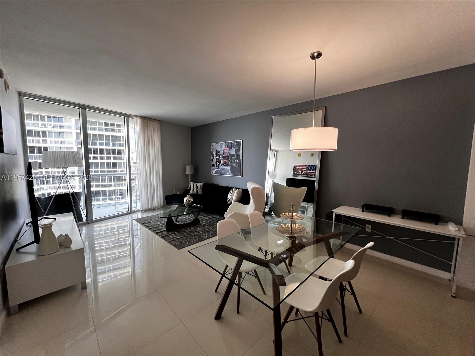 A modern living and dining area features white tile floors, gray walls, and floor-to-ceiling windows — 475 Brickell Ave # 4511, Miami FL 33131, MIAMI, FL