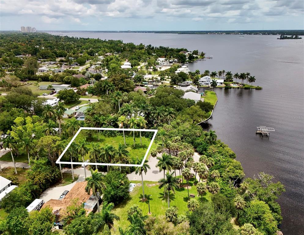 An aerial view shows a vacant, rectangular lot outlined in white near a waterfront — 304 ROYAL PALM PARK ROAD, FORT MYERS, FL