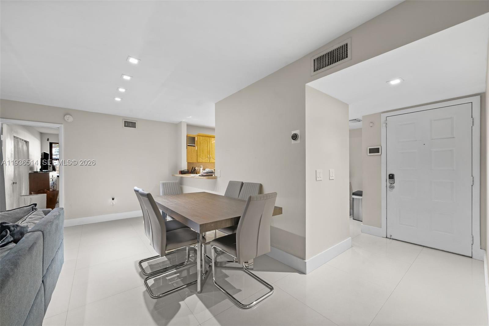 A dining area features a wooden table with four chairs on a tiled floor — 20310 NE 3rd Ct # 2, Miami FL 33179, MIAMI, FL