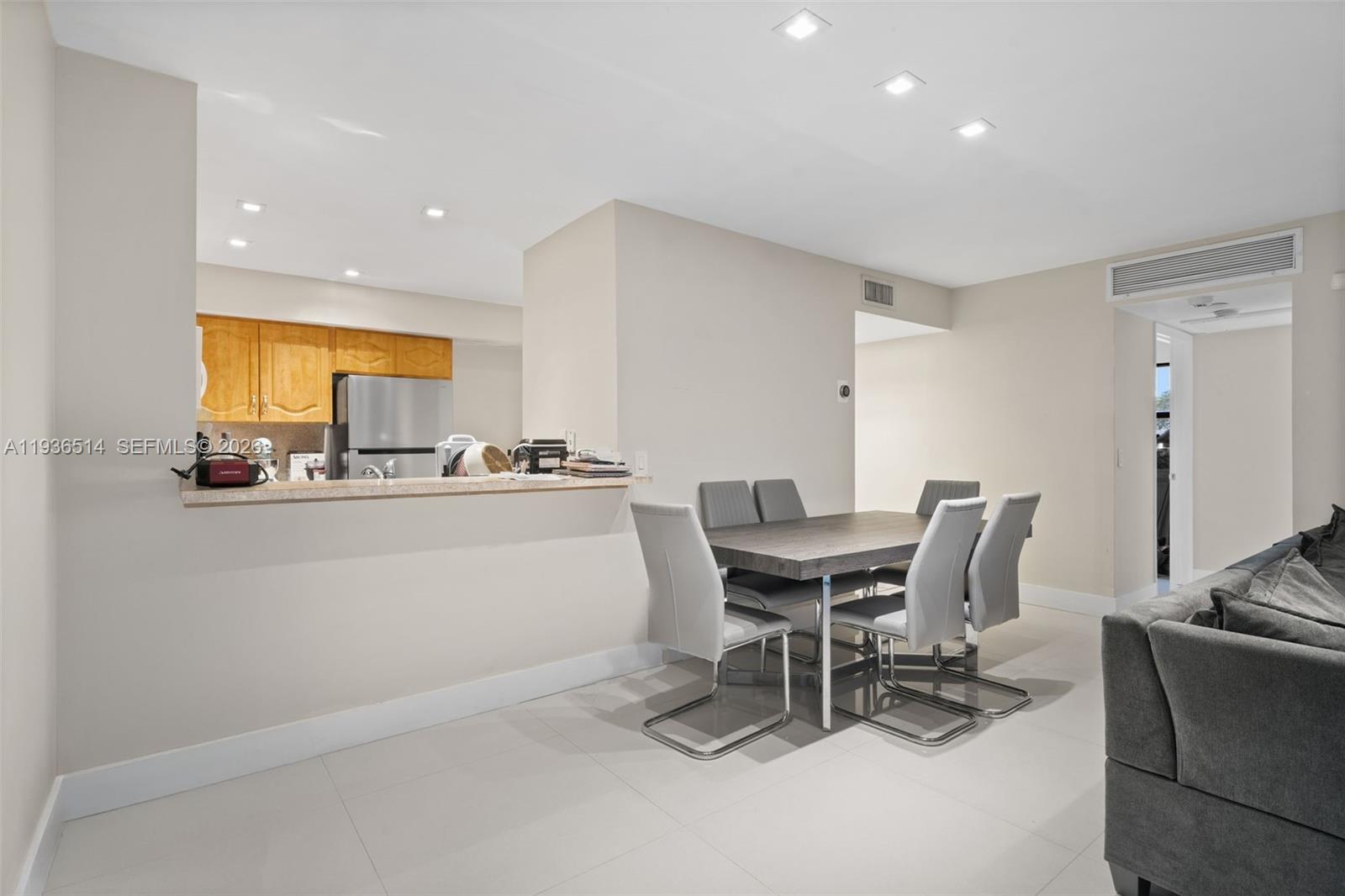 A dining area with a table and chairs sits adjacent to an open kitchen — 20310 NE 3rd Ct # 2, Miami FL 33179, MIAMI, FL