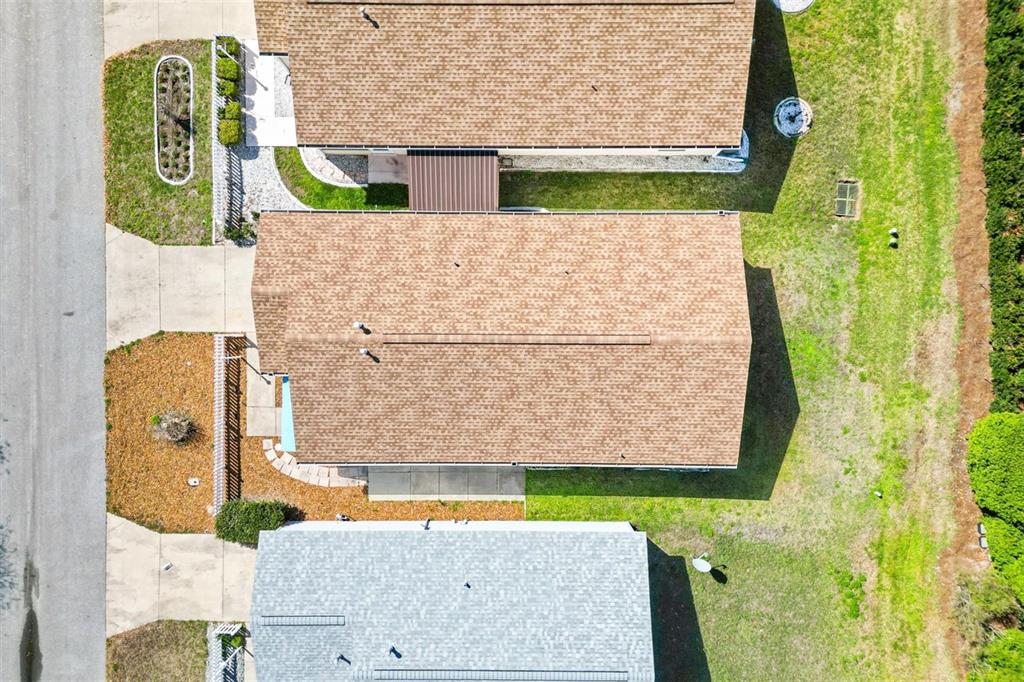 An aerial view shows three residential houses with shingled roofs and surrounding yards — 17470 SE 93RD VINE AVENUE, THE VILLAGES, FL