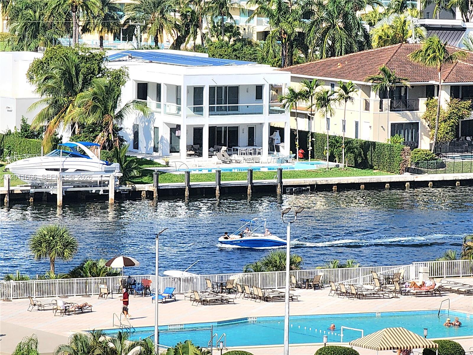An aerial view shows a waterfront house with a pool and a boat in the canal — 2030 S Ocean Dr # 1107, Hallandale Beach FL 33009, HALLANDALE BEACH, FL