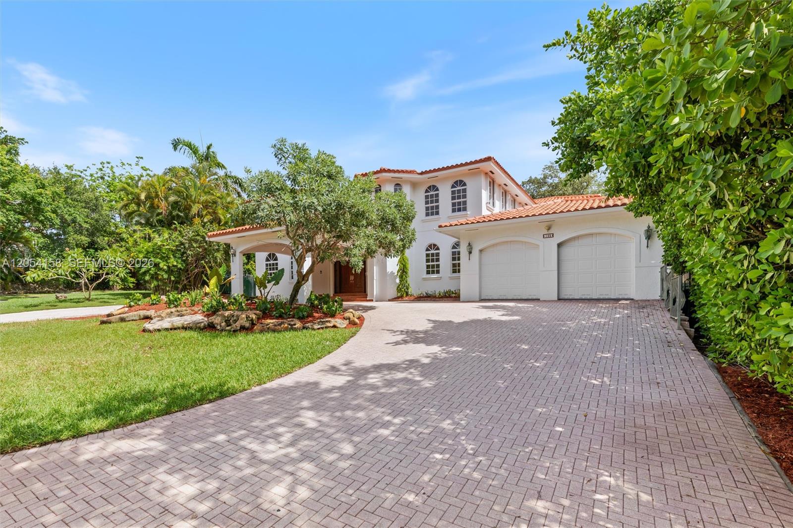 A two-story white house with a red tile roof and a paved driveway — 145 W Sunrise Ave, Coral Gables FL 33133, CORAL GABLES, FL