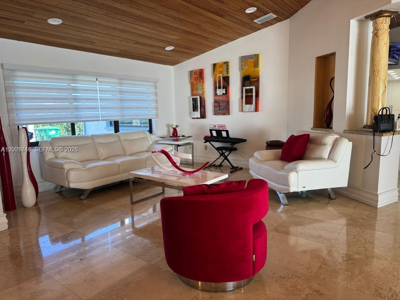 A living room features white leather seating, a red accent chair, and a wood-paneled ceiling — 3690 SW 139th Ave, Miami FL 33175, MIAMI, FL