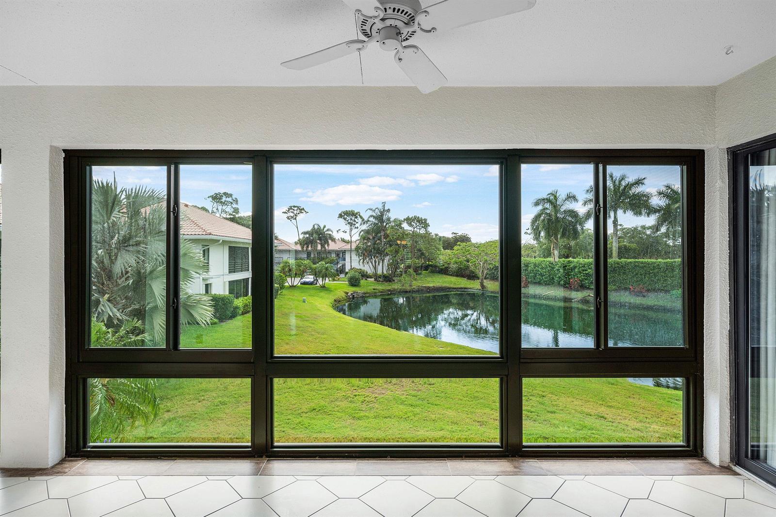 A sunroom with white tile flooring and a large window wall overlooking a pond — 4080-b Quail Ridge Drive, Boynton Beach FL 33436, BOYNTON BEACH, FL