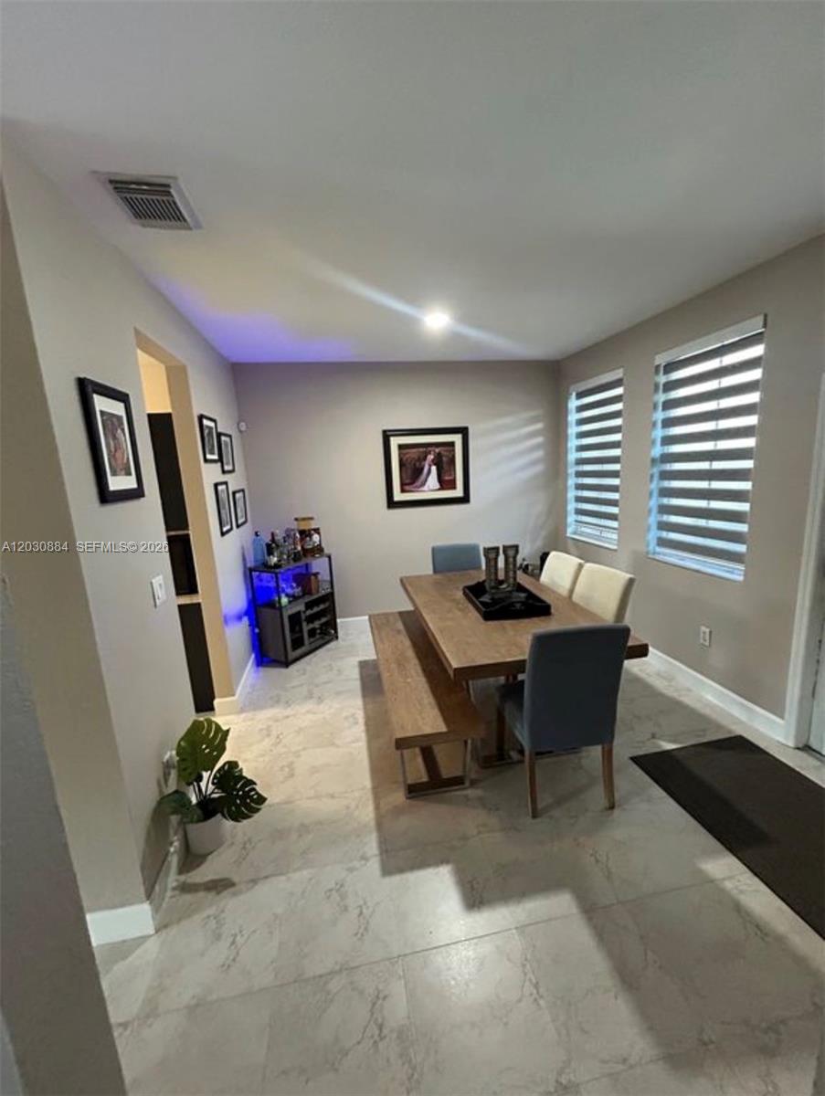 A dining room features a wooden table with a bench and chairs on tiled floors — 15372 SW 9th Way, Miami FL 33194, MIAMI, FL