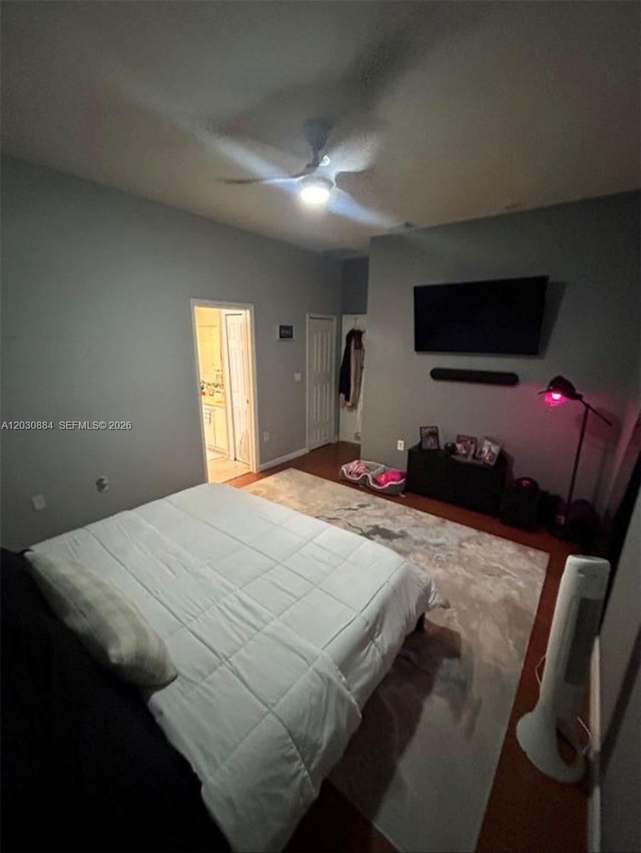 A bedroom features a bed, a wall-mounted television, a ceiling fan, and a rug — 15372 SW 9th Way, Miami FL 33194, MIAMI, FL