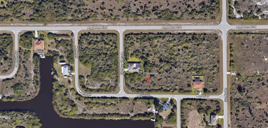 This is an aerial map view showing a residential lot with surrounding streets and vegetation — 14330 MONTMARTE AVENUE, PORT CHARLOTTE, FL