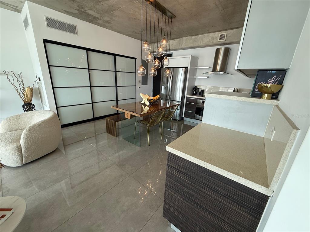 A modern kitchen area features a large frosted glass sliding door, tile flooring, and stainless-steel appliances — 403 DE LA CONSTITUCIÓN AVENUE UNIT 906, SAN JUAN, PR