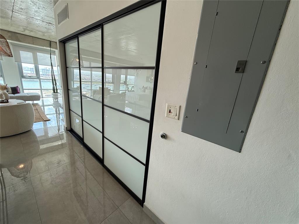 A modern kitchen and dining area features a glass-topped table, pendant lights, and concrete ceilings — 403 DE LA CONSTITUCIÓN AVENUE UNIT 906, SAN JUAN, PR